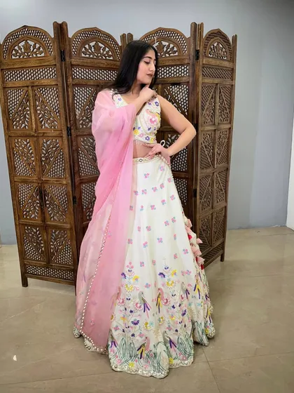 This white lehenga with colorful bird and floral embroidery is a whimsical and unique choice for a day event.