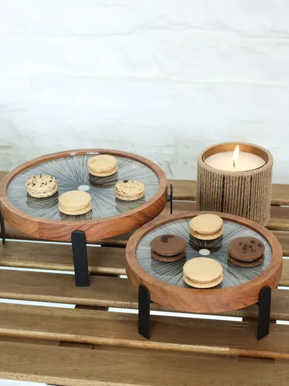 The Moon Ray stands with a black radial print, shown here with macarons. The contrast between the dark print and the warm wood creates a striking visual, perfect for a modern tablescape.