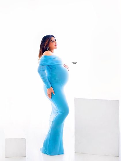 A full-length portrait showcasing the elegant simplicity of this blue maternity gown. The focus is all on the mamma and her beautiful twin bump.