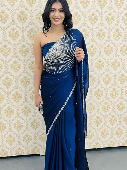 A full-length view of this stunning party look. The makeup perfectly complements her modern, one-shoulder beaded saree, making her ready for any glamorous occasion.