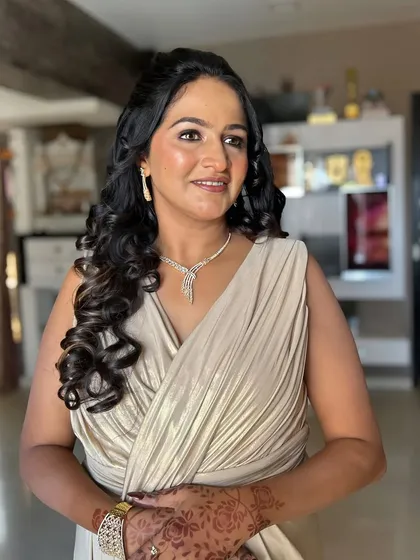 A glamorous look for an evening event. The client is wearing a draped gown, and her makeup is soft yet defined, with glowing skin and a neutral lip.