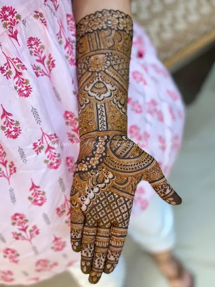 A detailed view of one arm from a bridal mehendi set. The patterns are a mix of traditional Indian motifs, creating a rich and textured design.