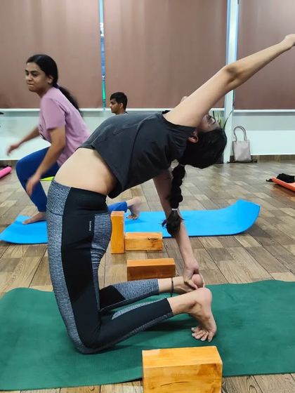 A student in a beautiful variation of Ustrasana (Camel Pose). This pose is a fantastic heart opener and helps to improve posture by stretching the entire front of the body.