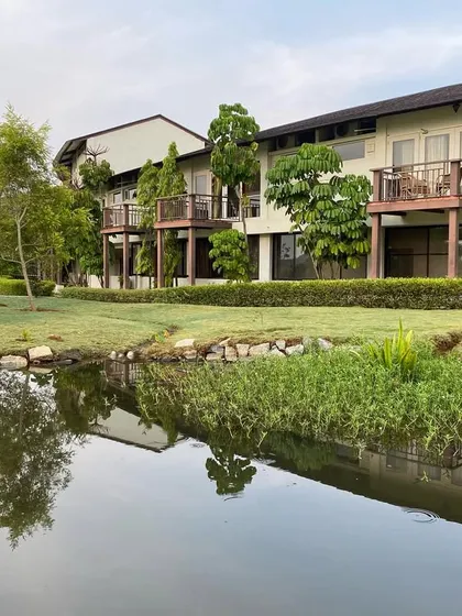 The guest cottages are situated beside a water body, reflecting the greenery. This design ensures that the calming presence of nature is always just a glance away.
