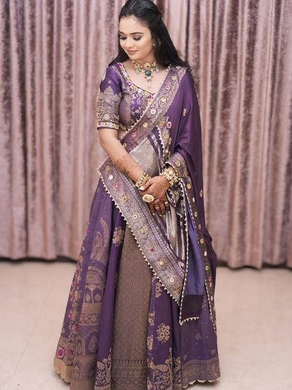 A full view of the stunning purple lehenga for her Gordhana ceremony. The soft, glowing makeup perfectly complements the regal and elegant outfit.