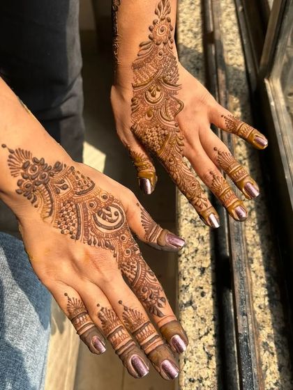 A classic back of hand or "sider" mehendi design. The pattern flows beautifully from the wrist down to the middle finger, leaving space for an elegant look.