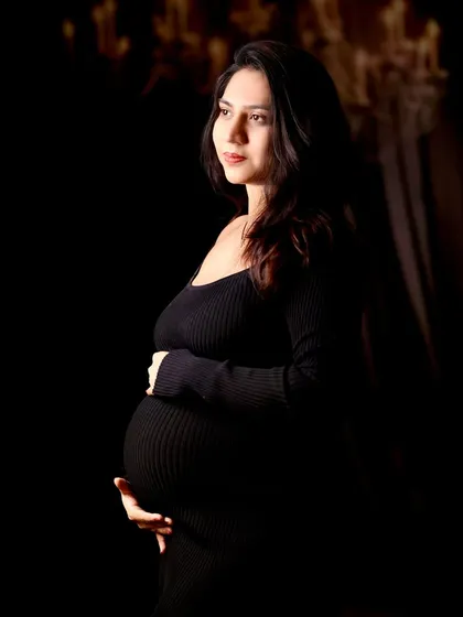 A classic, artistic maternity portrait that celebrates the quiet strength and beauty of motherhood. This is a sample of our fine art studio work, focusing on dramatic lighting and emotion.