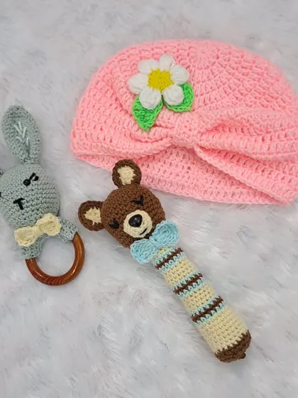 This gift set is all about sensory play, featuring a bunny teether rattle, a bear stick rattle, and a soft, turban-style baby hat.