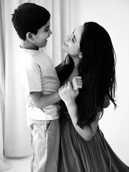 A timeless black and white portrait of a mother and son dancing. This image beautifully captures their loving gaze and the joy of their relationship.