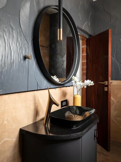 This powder room is an example of how I create "statement" bathrooms. The design uses a bold combination of black textured wall panels, caramel brown marble, and custom sanitary fixtures with gold accents to evoke a sense of dark, understated luxury.