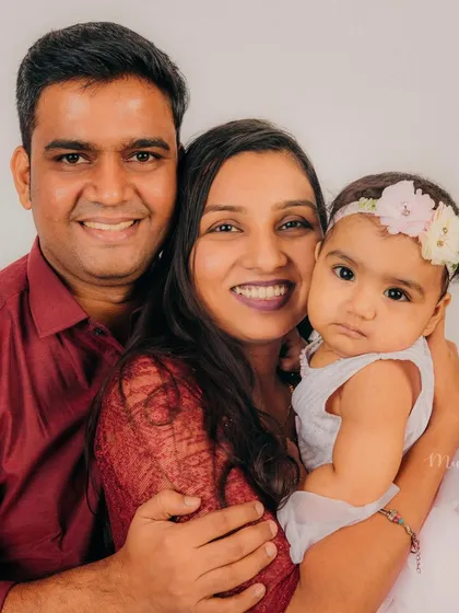 A warm, color portrait of a happy family. The baby's curious expression adds a touch of personality to this lovely shot.