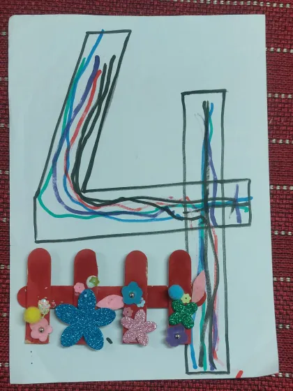 A beautiful craft combining number learning with art. The number '4' is decorated with colorful lines and a fence made of popsicle sticks and foam flowers.