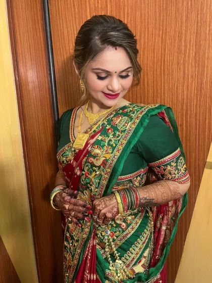A close-up of the client's makeup, showing the soft eye makeup and the beautiful red lip that complements her traditional attire.