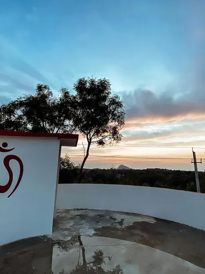 As the sun sets over the hills, a profound stillness settles over the ashram. The Om symbol on our wall is a constant reminder of the universal sound that connects us all. This is the peace you will find here, a quiet space to reconnect with your soul.