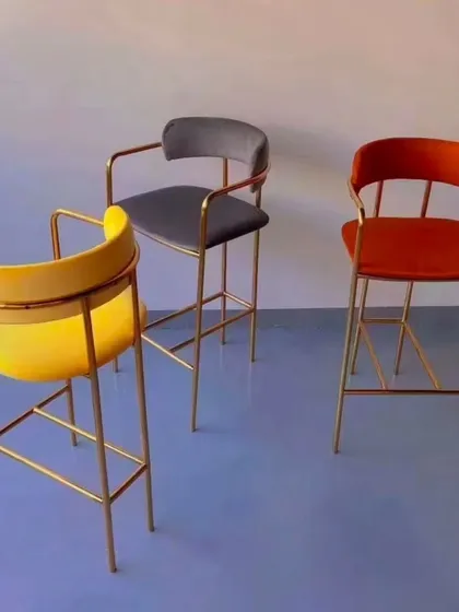 These high counter chairs feature a sleek, gold-plated metal frame and are available in vibrant colors. They add a touch of modern elegance to any bar or high-top seating area in a restaurant or cafe.