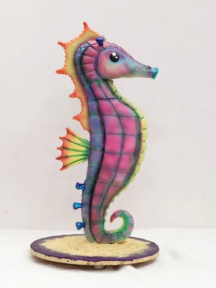 A side profile of the sculpted seahorse cake, showcasing its graceful curve and vibrant colors.