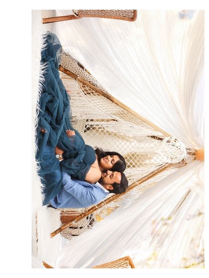 An artistic, rotated aerial shot of a couple cuddling inside a boho-style teepee, creating a unique and intimate perspective.