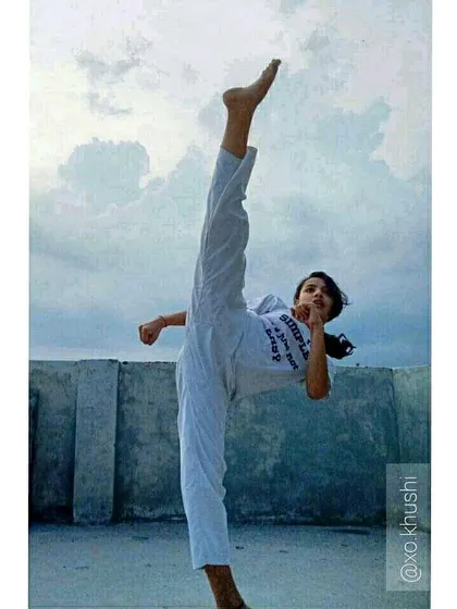 A student executes a perfect vertical kick, showcasing incredible flexibility and control. We push our students to constantly seek new heights in their training.