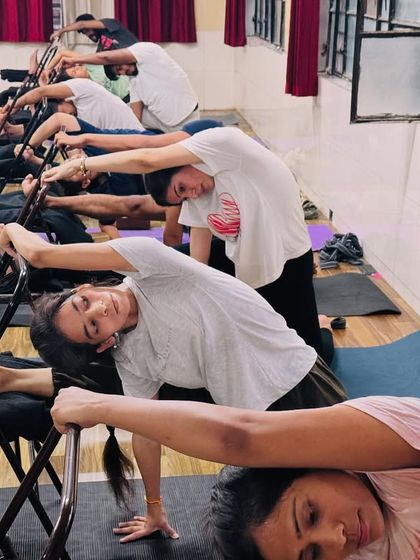 A closer look at the supported side stretch, showing how students can modify the pose to suit their flexibility level.