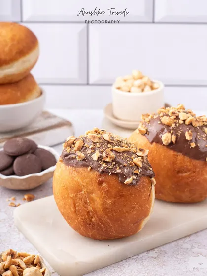 Another angle of the hazelnut bombolonis, emphasizing their golden-brown crust and generous nutty topping.