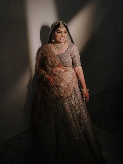 A full-length bridal portrait with artistic use of shadow and light, creating a sense of anticipation and elegance.