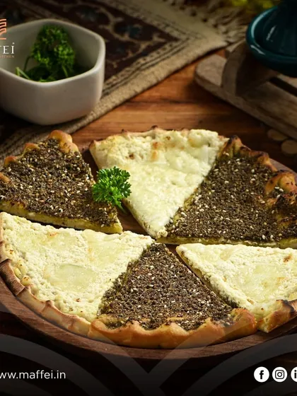 Our half-and-half Manakeesh, featuring one side with aromatic za'atar and the other with creamy, savory cheese. It's the best of both worlds on one delicious flatbread.