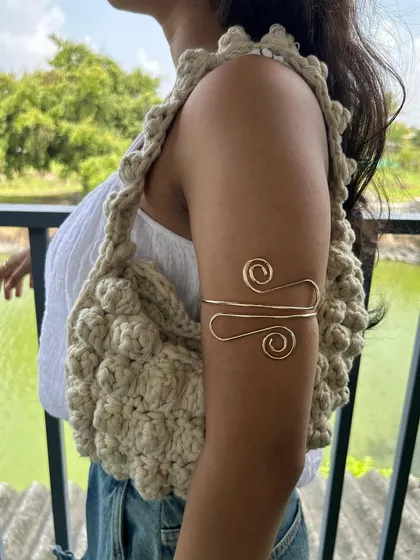 A side view of the puff stitch bag, showing how comfortably it sits on the shoulder. The strap is also crocheted with a sturdy stitch to ensure it's durable.