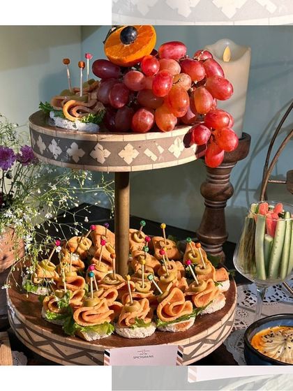 A two-tiered stand showcasing our delicious canapés and fresh grapes. An elegant and simple addition to any appetizer spread.