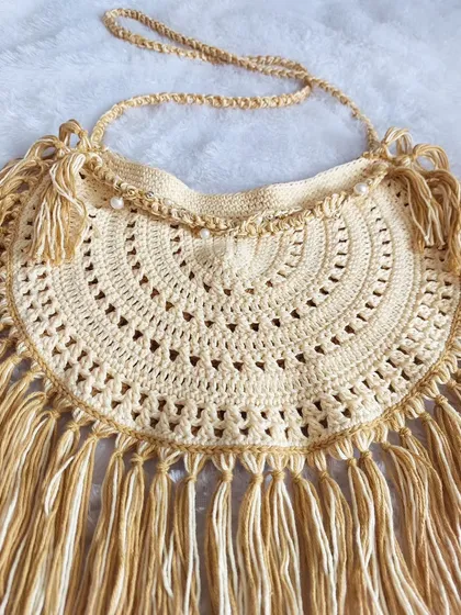 A detailed flat-lay of the Callaia Bag, focusing on the intricate stitchwork and the texture of the fringe.