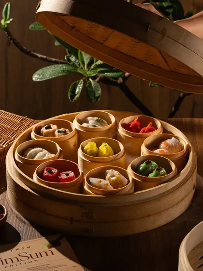 A close-up of a dim sum basket being opened. This shot is about the reveal, building anticipation for the delicious dumplings inside.