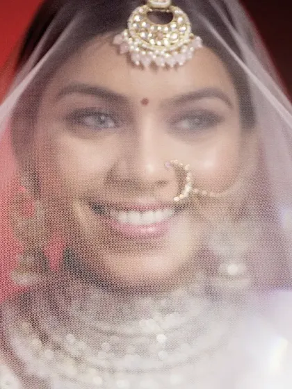 A beautiful close-up of the bride smiling through her veil. This classic shot is full of anticipation and happiness.