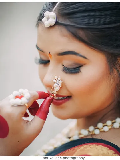 A close-up shot focusing on the delicate details of the 'halwyache dagine' (sugar ornaments) and nath worn for Makar Sankranti.