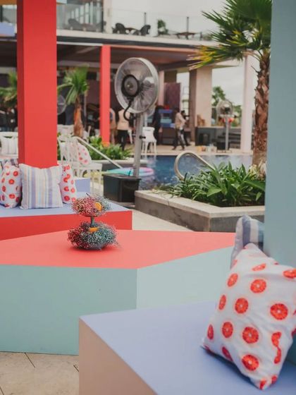 A close-up of the colorful, geometric seating blocks and custom cushions. Even the pineapple centerpieces were decorated to match the theme.