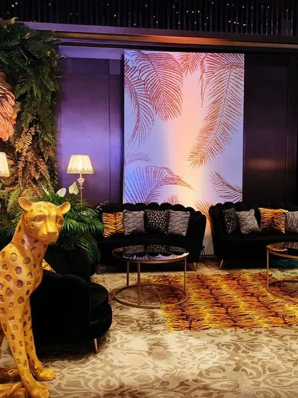 This lounge area was part of a "Walk on the Wild Side" gala. I used animal-print fabrics, a statement cheetah prop, and dramatic lighting against a custom backdrop to extend the jungle theme and create a cohesive, immersive world.
