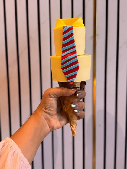 A single, detailed shot of the shirt and tie cakesicle. Each element is carefully crafted to create a sharp, clean look, making it a sophisticated and tasty gift.