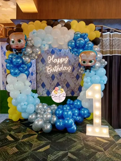 A Boss Baby themed first birthday with a square balloon frame, neon sign, and marquee number '1'.