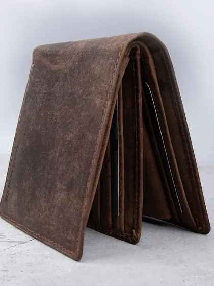 A side view of the distressed leather wallet, showing its capacity and layers.