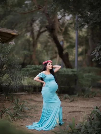 A full-length portrait in a park setting, showing off the beautiful fit and flow of the light blue gown.