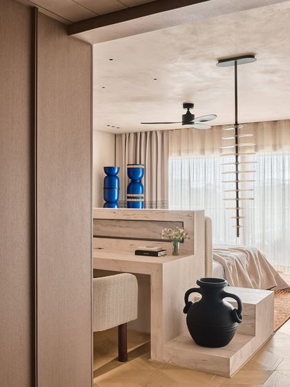 We designed this study nook as part of a larger bedroom suite, using a consistent palette of light wood and neutral tones. The bold blue ceramic vases add a surprising pop of color, showcasing our love for artful, unexpected details.
