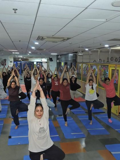 Our staff members practicing the tree pose (Vrikshasana) during a group yoga session, demonstrating balance and focus.
