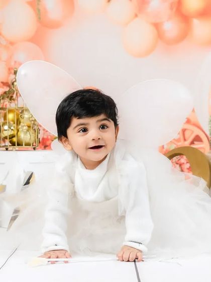 This little angel is on the move, crawling towards his destiny. A dynamic and adorable shot from a first birthday session.