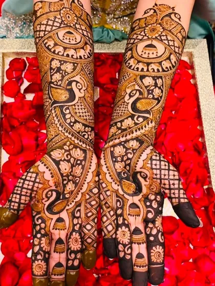 This stunning design features four peacocks, two on the palms and two on the forearms, set against a backdrop of intricate net and floral patterns.