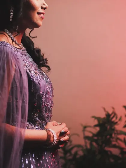 A candid portrait of a bride at her reception. The soft, colored lighting and her thoughtful expression create a beautiful and artistic image.
