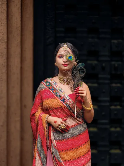 A moment of grace. This artistic portrait, taken for Navratri, uses traditional elements like the peacock feather and colorful saree to create a vibrant and culturally rich image.