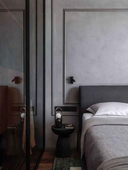 Headboards combined with wall trims and paint give the ultimate aesthetic look. This design uses a simple grey upholstered headboard against a wall with classic moulding for a touch of understated elegance.