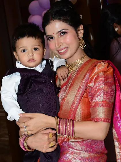 A beautiful moment shared by a happy client, looking radiant in her traditional saree at her son's birthday party.