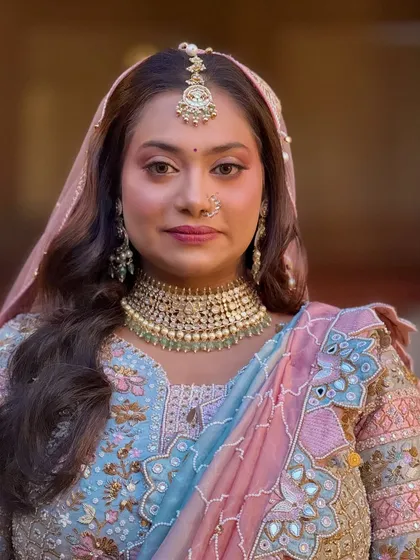 A close-up portrait showing the flawless skin and the beautiful pink-toned eye makeup.