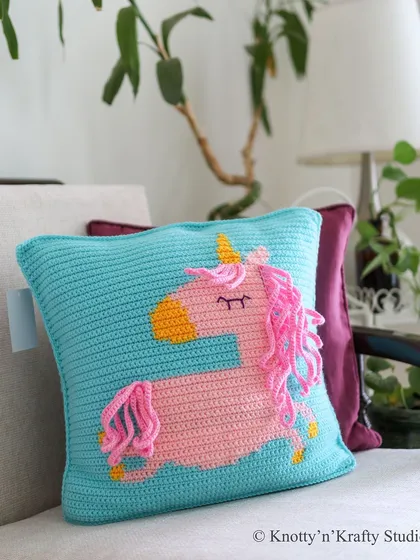 A happy Sunday moment with the Curly Tails Unicorn Cushion. The bright aqua blue pillow provides a perfect backdrop for the pink unicorn with its fun, curly mane and tail.