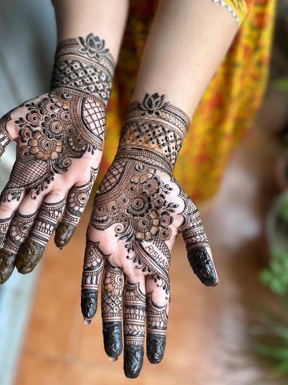 The full view of this festive Karwa Chauth henna, with the client's name 'Risha' subtly included in the design.