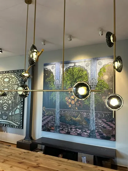 Another angle of the Ceto chandelier, showing how the light reflects off the textured glass, creating a shimmering effect reminiscent of light on water.